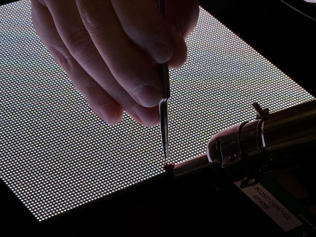 Techniker lötet LED-Panel-Komponenten vor Montage – LED Wall Service von projektor.at